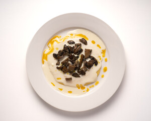 Typical Friulian dish "Toc in braide" with polenta, cheese and mushrooms. White background