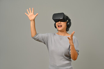 Portrait of amazed senior woman VR headset enjoying virtual reality experience. Modern technologies, innovations and gadgets