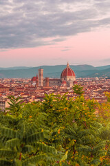 Fototapeta na wymiar Panoramic view of Florence from Piazzale Michelangelo at pink sunrise. Cathedral of Santa Maria del Fiore and streets of an ancient Italian city.