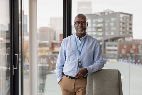 Portrait of senior black businessman in corporate office with view of city skyline
