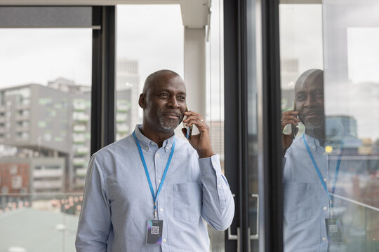 Senior black businessman in corporate office talking on smartphone 