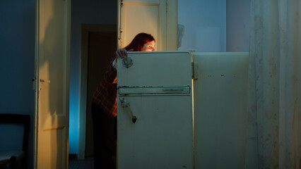 Woman looks into a fridge