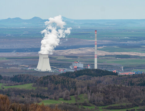 moking coal fired power plant and steam rising from a cooling tower. Ecological burden and environmental looting.