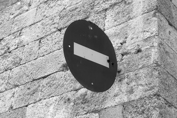 Black and white do not enter traffic stop sign hanging from a brick stone background wall....