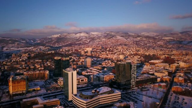 Aerial cinematic drone snowy roads winter Olympic downtown snowy frozen Sarajevo City town center Bosnia and Herzegovina landscape afternoon sunset golden purple circle right movement