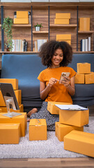 African American business woman working at warehouse preparing SME package box for delivery at...