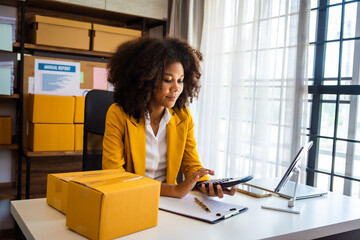 African American business woman working at warehouse preparing SME package box for delivery at small business home office. - obrazy, fototapety, plakaty