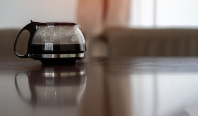 Close-up of electric glass coffee pot is on the wooden table for preparing breakfast