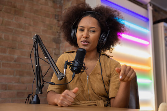 Influencer recording a podcast in a studio pointing to like button