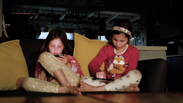New age kids with advanced digital literacy from young age, twins on smartphones