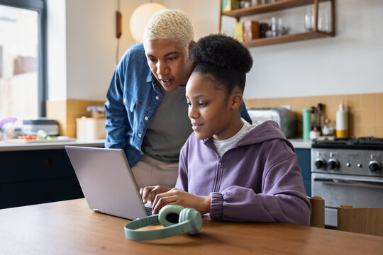 Mom looking at daughters school work on laptop
