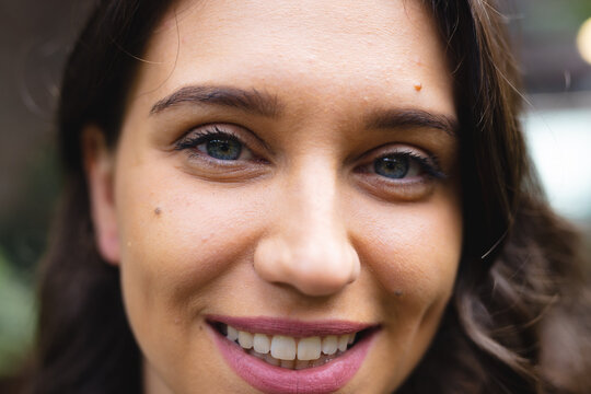 Close up portrait of happy caucasian businesswoman looking at camera and smiling, unaltered