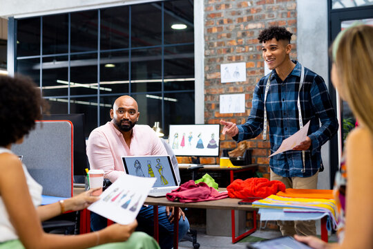 Happy diverse fashion designers discussing fashion projects at meeting in creative office, unaltered - Powered by Adobe