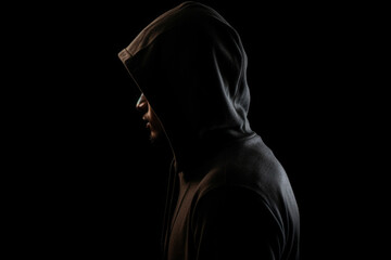 Mysterious man wit hoodie in silhouette isolated on black background