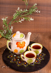 Indian masala chai or tea in cup, with kettle, spices and tea leaves on dark, wooden background. cafe, retro, restaurant, vintage, ethnic, healthy, hotel concepts.