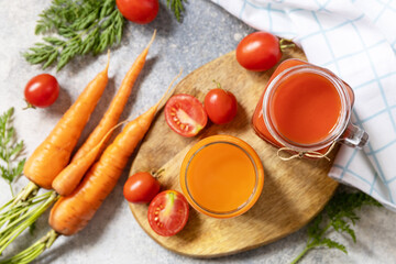 Tomato and carrot juice in a glasses on a stone table. Vitamins drinks juice carrot and tomato. Healthy lifestyle. View from above.