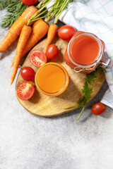Tomato and carrot juice in a glasses on a stone table. Vitamins drinks juice carrot and tomato....