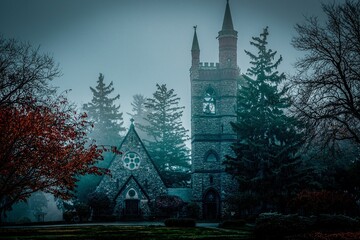 Scenic view of an old gothic graveyard church in a mysterious forest on a gloomy day