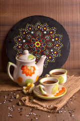 Indian masala chai or tea in cup, with kettle, spices and tea leaves on dark, wooden background. cafe, retro, restaurant, vintage, ethnic, healthy, hotel concepts.