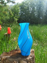 3D printed vase. 3D printed vase with green grass and bushes in the background