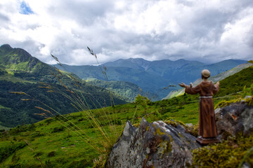 Fototapeta na wymiar Scenic view of the Pyrenees mountain range with a father statue under the cloudy sky in France