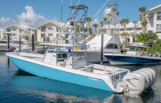 Horizontal shot of a blue contender fishing boat at Ocean Reef Club with white houses in the behind
