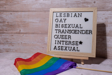 LGBTQIA description frame on Rainbow LGBTQIA flag made from silk material. LESBIAN, GAY, BISEXUAL,...