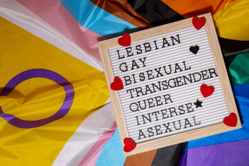 LGBTQIA description frame on Rainbow LGBTQIA flag made from silk material. LESBIAN, GAY, BISEXUAL,...