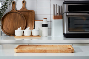 Modern kitchen interior with full appliances - wooden cutting board, spice boxes, knife tray and...