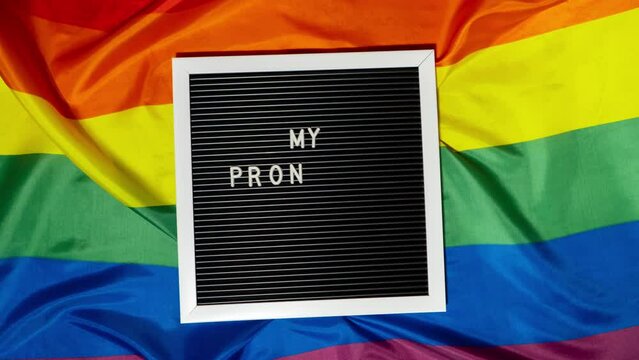 Stop motion of MY PRONOUNS ARE text Neo pronouns concept on Rainbow flag background gender pronouns. Non-binary people rights transgenders. Lgbtq community support assume my gender, respect pronouns