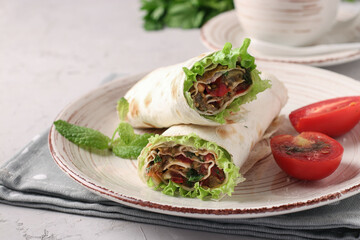 Lavash roll with eggplant, tomato, garlic and lettuce leaves on gray background, Homemade appetizer
