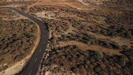 Aerial shot of road running through barren desert terrain in Tenerife, Canary Islands