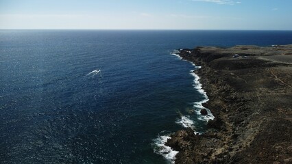 Fototapeta na wymiar Aerial view of a boat sailing near the coastal Tenerife in Canary Islands of Spain