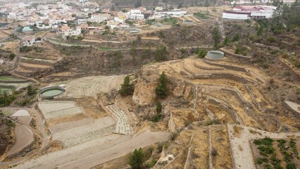 Fototapeta premium Aerial shot of terrace farms amd irrigation tank on mountainside, Tenerife, Canary Islands