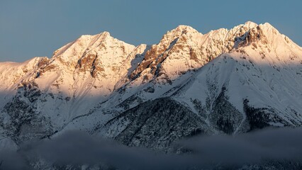 Beautiful shot of the Nordkette range of snowy mountains against a blue sky