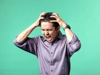 A portrait of an Asian man wearing a purple shirt, while being angry and frustrated with his hand...