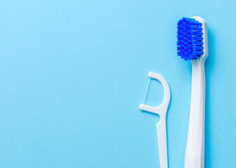 White toothbrush and dental floss on a blue background. Template Copy space for text