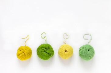 Summer needlework and knitting. Top view of four skeins of green and yellow hand knitting yarn on...