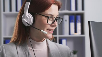 customer service, a friendly woman in glasses works as a call center operator and consults with buyer while sitting in office