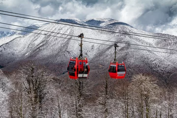 Wandcirkels tuinposter Gondola lift against the backdrop of a winter mountain forest © Dushlik