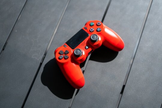 Top view of a red PlayStation 4 controller ps4 on a grey wooden table