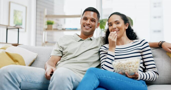 Movie, watching tv and couple at home on a living room couch eating popcorn together. Television, house and film food of a man and woman relax with a series and video on sofa with communication