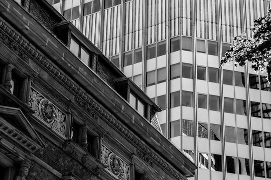 Grayscale beautiful view of an old and modern building with small windows