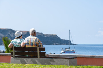 Fototapeta na wymiar pareja de personas mayores sentados vista al mar