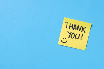 Sticky notes with text THANK YOU on blue background with copy space.