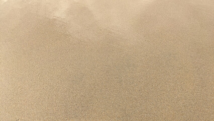 Fototapeta na wymiar Sandy beach and water reflection