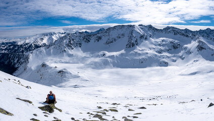 back view of unrecognisable person, man in hat at snowy winter landscape,sunny cold frosty weather Sunrise in mountain. High Tatras Mountain in Poland and Slovakia