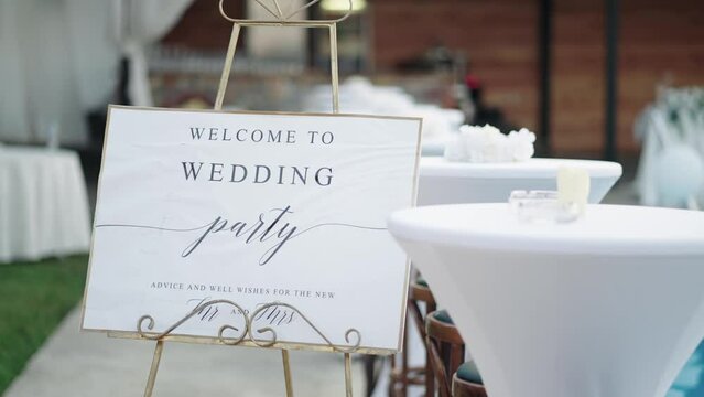 A welcome board sign with a beautiful flower and rustic decoration, standing in front of wedding entrance