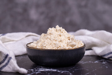 Garlic powder on wooden background. Dried ground garlic powder spices in wooden bowl