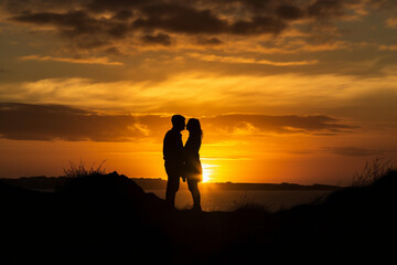 Silhouetted loving couple at sunset